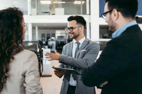 People discussing vehicle options at a car dealership